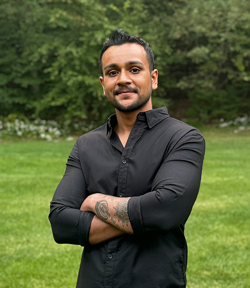 Priten Soundar-Shah standing outdoors with arms crossed, smiling